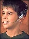 A kid smiling with an orthodontic headgear